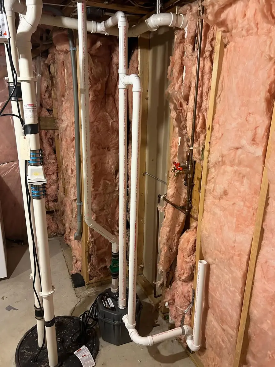 Ejector pump basin and white PVC discharge piping