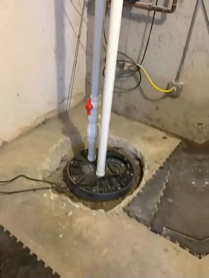 New ejector pump in its basin with the white discharge pipe