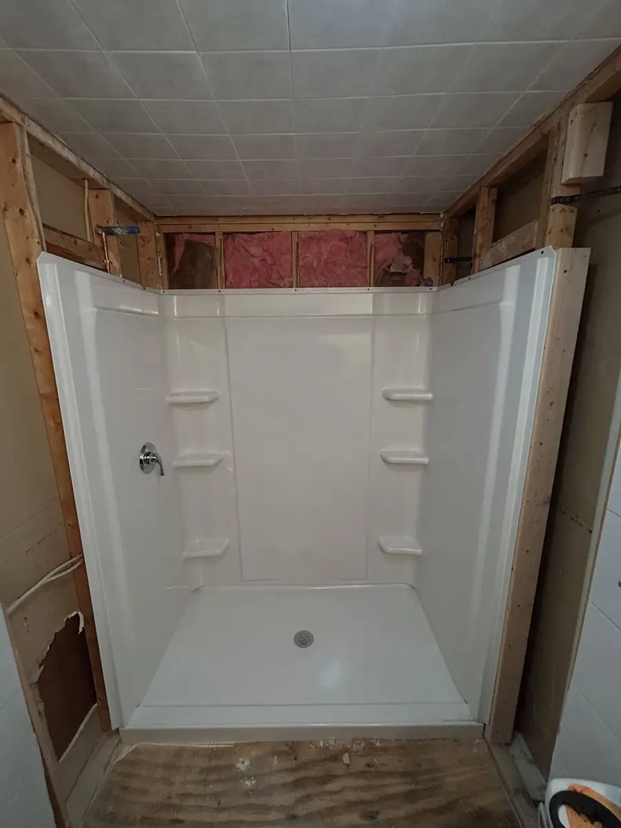 New walk-in shower stall set in the alcove