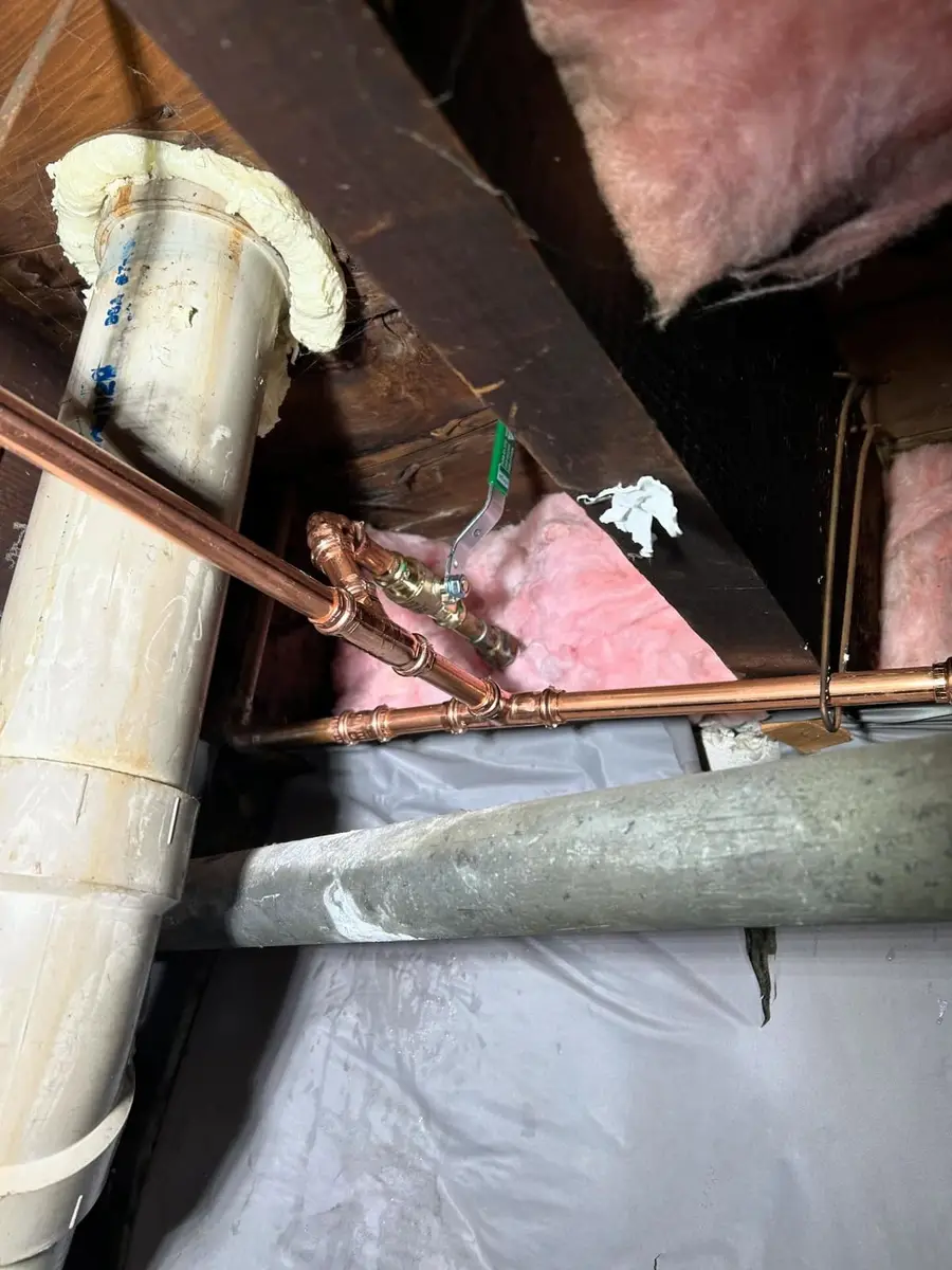 Copper supply repiped with press fittings beside a drain
