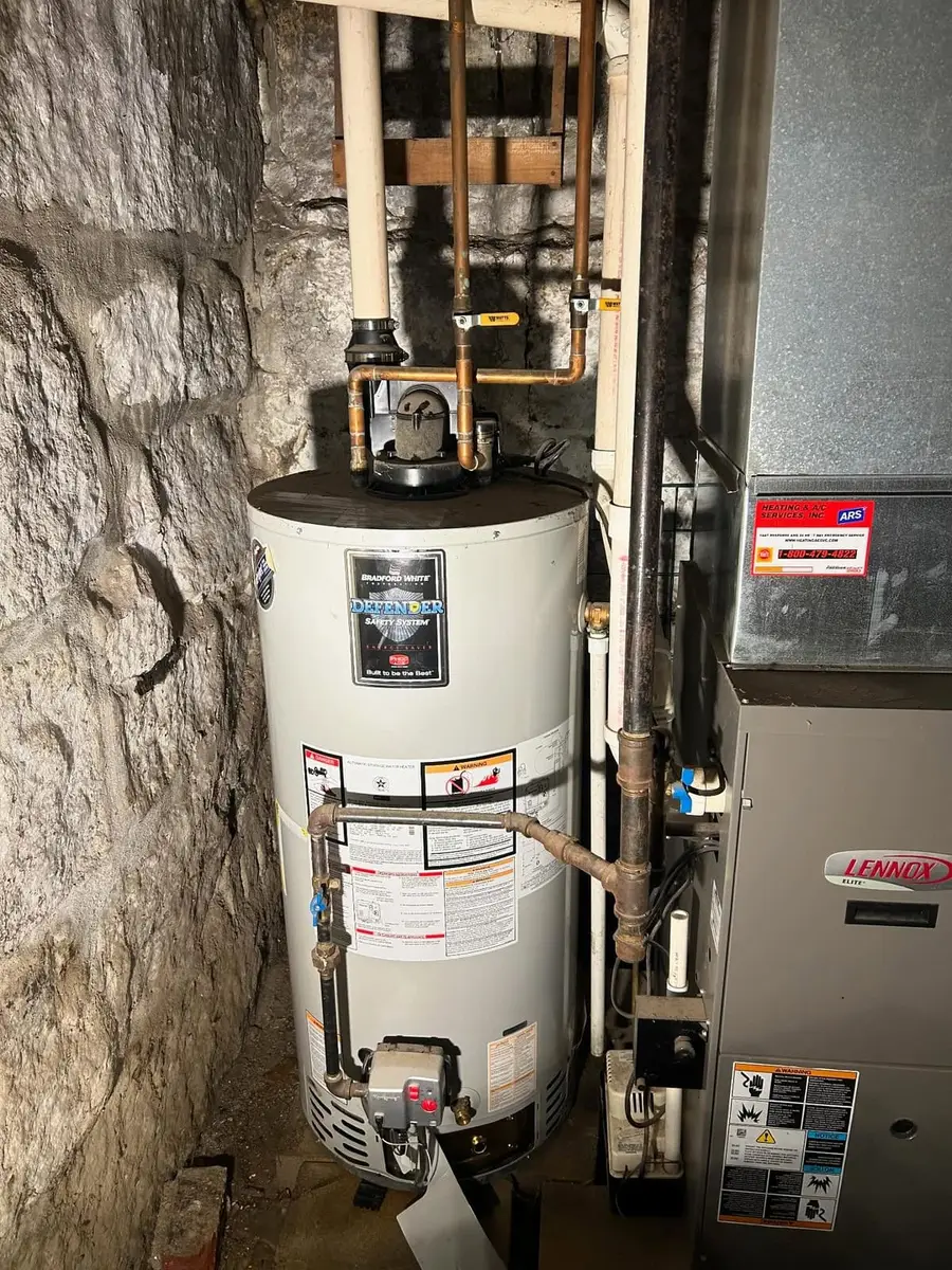 Old gas water heater next to a furnace