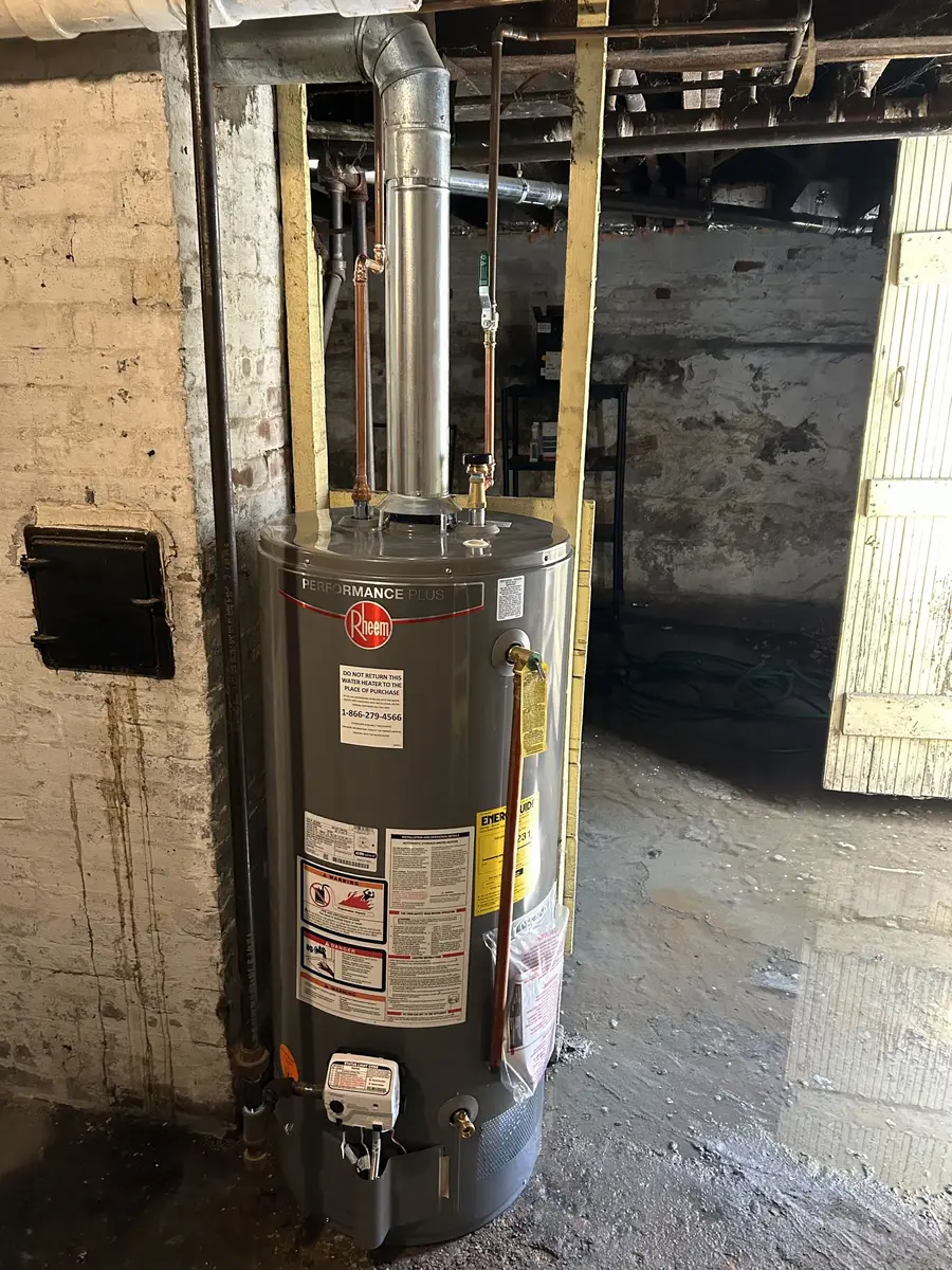 A finished single water heater installation in an open basement