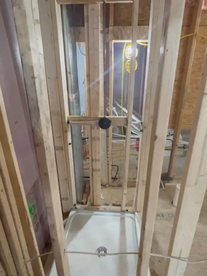 Shower pan set between framed studs before the walls are closed